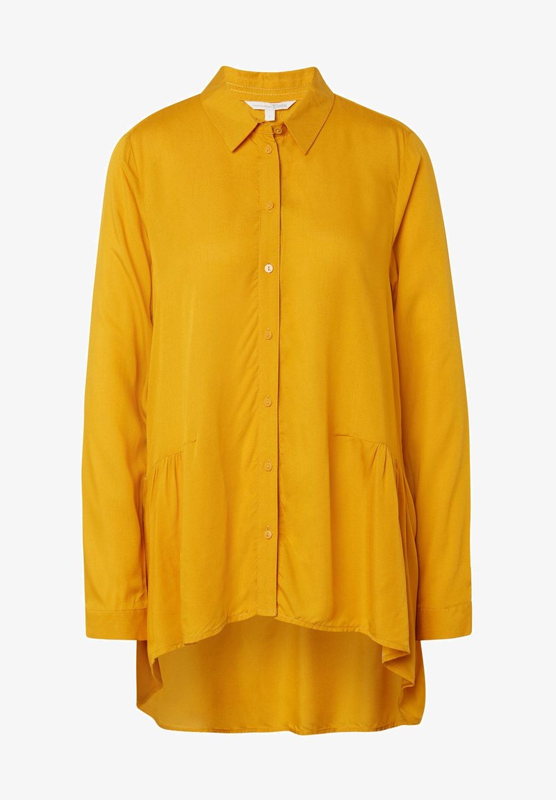 Damska koszula na guziki w kolorze musztardowożółtym, z długimi rękawami, szpiczastym kołnierzykiem oraz asymetrycznym dołem.
