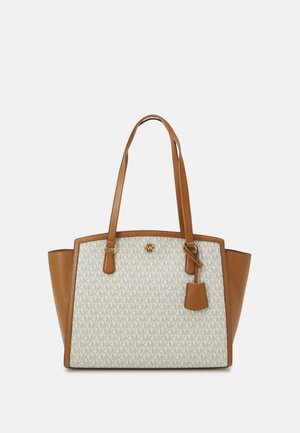 Sac fourre-tout en toile avec accents en cuir beige, présentant un motif de logo intégral, des détails en métal doré, des anses doubles, et une étiquette de logo amovible.