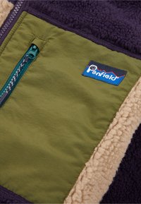 Fleece jacket with olive green fabric, beige shearling, and dark purple accents. Features a zipper pocket and a Penfield logo.