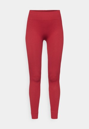 Rdeče rebraste legging hlače z visokim pasom, ki se prilegajo telesu in imajo gladko teksturo, segajo do gležnjev. Brez vidnih okrasnih elementov.