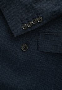 Giacca da abito blu navy con tessuto testurizzato, dotata di quattro bottoni neri coordinati e di una tasca a filetto.