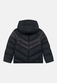 Casaco puffer preto com capuz, apresentando um design em matiz de chevron e um acabamento texturizado. Inclui uma etiqueta da marca na parte inferior esquerda.