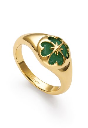 Guldring med et grønt firkløver-design på toppen, glat ring, og indgraveret mærkenavn indeni.