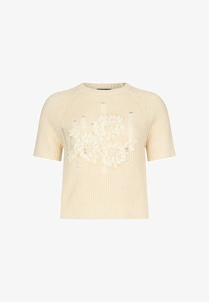 Kreemjas lühikeste varrukatega kudumist kampsun soonilise tekstuuri ja lilleliste tikanditega, kus esipaneelil on reljeefsed kroonlehed ja lehed.