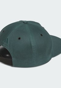 Gorra verde de tela, con visera curva, ojales de ventilación y una correa ajustable. Presenta un detalle de logo sutil.