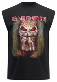 Černý bezrukávový top s grafikou lebky s červenýma očima a dlouhými vlasy, která zobrazuje gesto ruky. Nad ním je text "Iron Maiden".