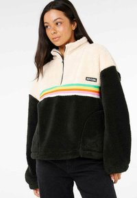 Fleece-Pullover mit creamfarbenem Oberteil, schwarzem Unterteil und lebhaften horizontalen Streifen. Halbreißverschluss, strukturierter Stoff, Logo-Patch auf der Brust.