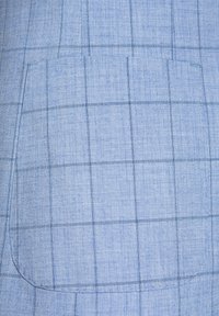 Jasnoniebieska tkanina z delikatnym wzorem w kratkę. Zawiera kieszonkę łatkową z zaokrąglonymi krawędziami, z przeszyciami oraz gładką fakturą.