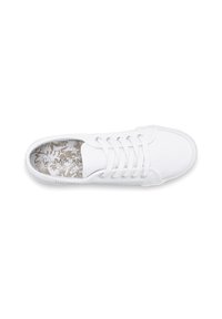 White canvas sneaker with lace-up design, silver eyelets, and textured inner sole featuring a floral pattern. Rubber outsole for traction.