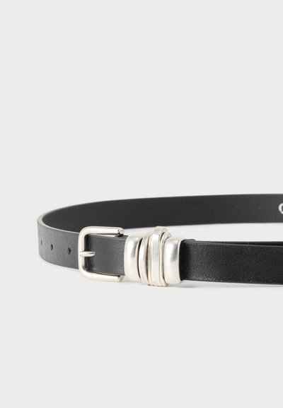 Ceinture en cuir noir avec boucle argentée et trois anneaux décoratifs argentés sur fond gris clair.