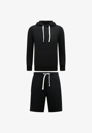 Zwarte hoodie met voorzak en witte trekkoorden gecombineerd met zwarte korte broek met witte trekkoord tailleband op een witte achtergrond.