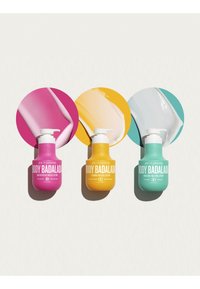 Tres botellas de loción coloridas con muestras de loción a juego detrás de ellas: rosa, amarillo y verde azulado, etiquetadas como Body Badalada de Sol de Janeiro.