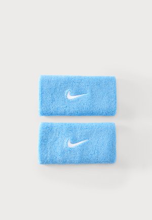 Deux bracelets Nike bleu clair avec des logos swoosh blancs placés sur un fond gris clair.