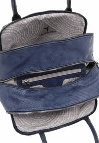 Marineblaue Lederhandtasche mit perforierter Textur, Reißverschlussfächern und einem hellgrauen gemusterten Innenfutter mit Markentext.