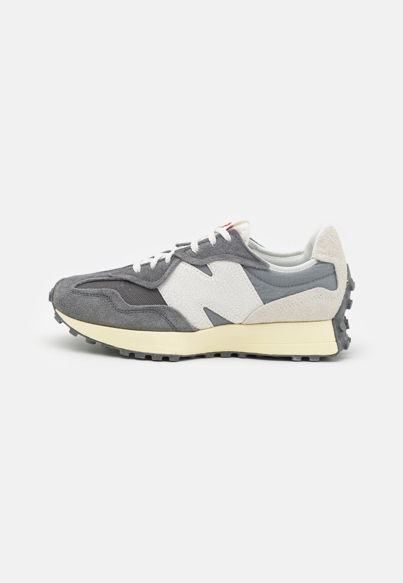 Szare i białe zamszowe sneakersy z kremową podeszwą, fakturowanym logo "N" oraz wytrzymałą czarną gumową podeszwą, pokazane z prawej strony na białym tle.