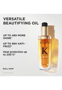 Kérastase Elixir Ultime verfraaiende olie in een doorzichtige fles met een gouden pompje; amberkleurige vloeistof; beweert glans te verbeteren en het haar te beschermen tegen hitte.