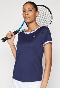 Camiseta deportiva navy de manga corta, con un cuello de patrón y un logotipo en el pecho. Tela suave, diseñada para la comodidad y el rendimiento.