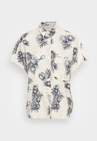 Chemise à manches courtes en tissu beige avec des motifs floraux et de feuilles noirs, bouton devant et poche poitrine unique.