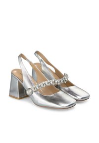 Srebrne sandały na obcasie typu slingback z kwadratowym noskiem i słupkiem. Wyposażone w dekoracyjną pasek ozdobiony cyrkoniami na górze. Gładkie metaliczne wykończenie.