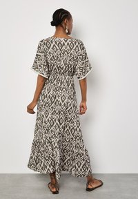 Maxi jurk in een lichtbeige en olijfgroen patroon, met een trekkoord in de taille, korte mouwen, een gelaagde rok en een gestructureerde stof.