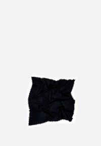 Manta negra, texturizada, con un aspecto suave y arrugado. Presenta flecos a lo largo de los bordes y un color oscuro y intenso.