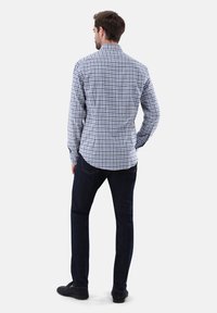 Blaue und weiße kariertem Hemd, langärmlig, mit Button-Down-Kragen, taillierte Passform, getragen mit dunklen Jeans, von hinten betrachtet.