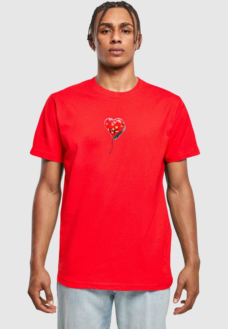 Rød kortærmet T-shirt lavet af bomuld, med et hjerteformet ballon-design med et blomstermønster på brystområdet.