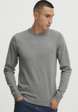 Grey knitted sweater with a crew neck, long sleeves, and ribbed cuffs and hem. Smooth texture, minimalistic design, no visible patterns or logos.