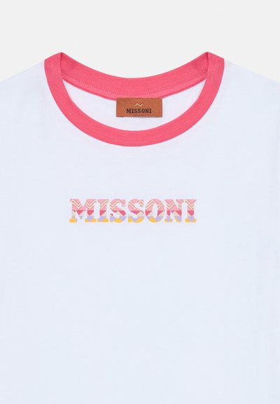 Camiseta blanca con un escote acanalado rosa. Presenta "MISSONI" en una fuente de patrón multicolor, con una etiqueta de cuero marrón en el cuello.