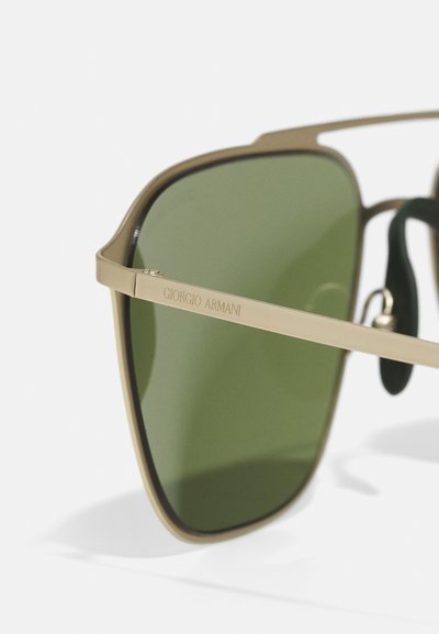 Ochelari de soare Giorgio Armani cu lentile verzi, ramă din metal aurie, formă dreptunghiulară și branding gravat pe braț. Accente din cauciuc pe suporturile pentru nas.