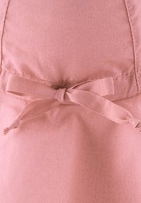 Rosa Stoff mit glatter Textur, versehen mit einer Schleifen-Detail aus demselben Material, das in der Taille befestigt ist. Einfaches Design, matte Oberfläche.