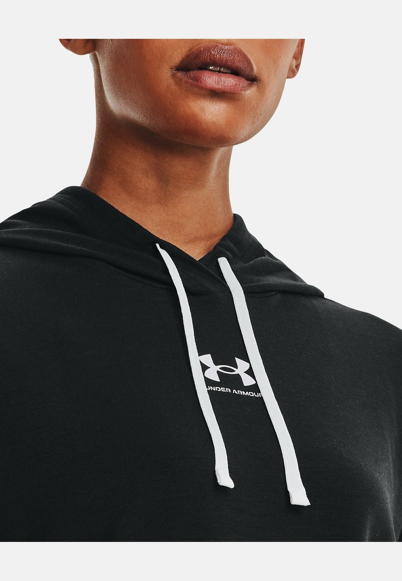 Sudadera negra de tejido suave, con un cordón blanco y un logo de Under Armour blanco en el pecho. Diseño minimalista.
