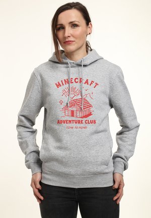 Szary hoodie z kangurową kieszenią, z czerwonym graficznym napisem "Minecraft Adventure Club" i blokową ilustracją domu.