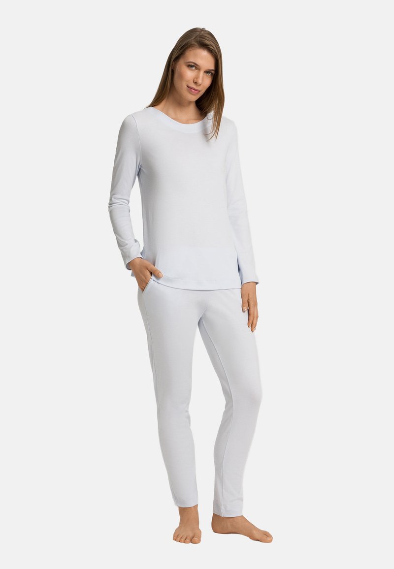Světle modrý loungewear set vyrobený z hladké tkaniny, obsahující top s dlouhým rukávem a kulatým výstřihem a přiléhavé kalhoty s elastickými manžetami.