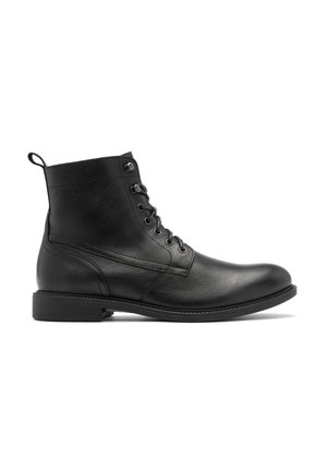 Botín de cuero negro con un acabado liso, punta redonda, diseño con cordones y un sutil detalle de costura en la parte superior y lateral.