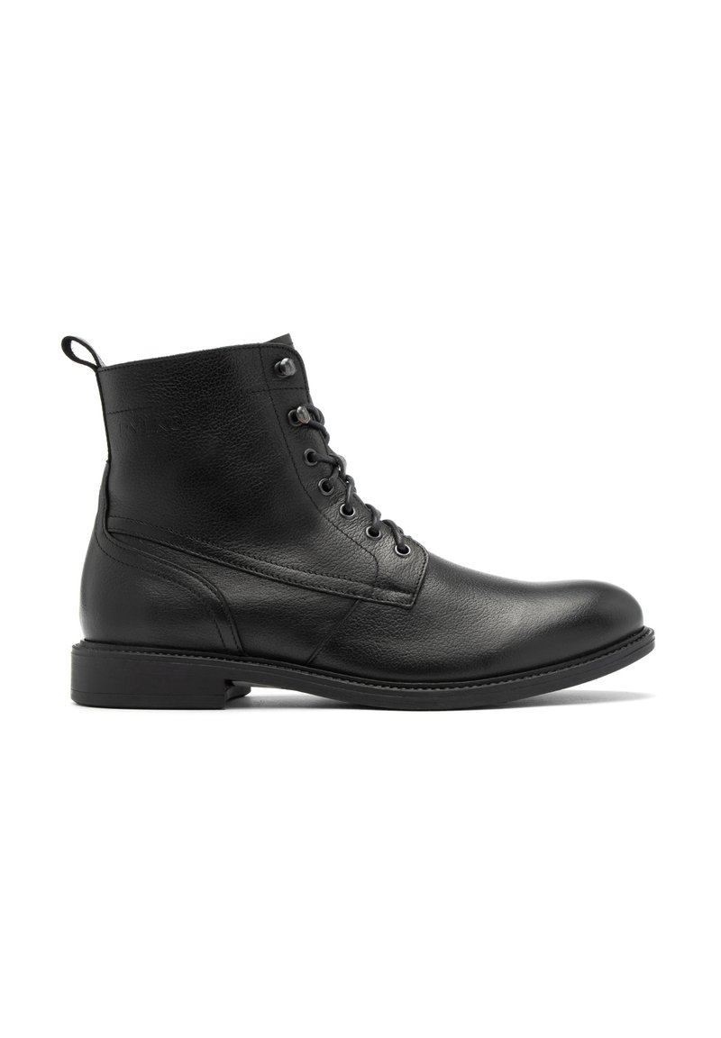 Botín de cuero negro con un acabado liso, punta redonda, diseño con cordones y un sutil detalle de costura en la parte superior y lateral.