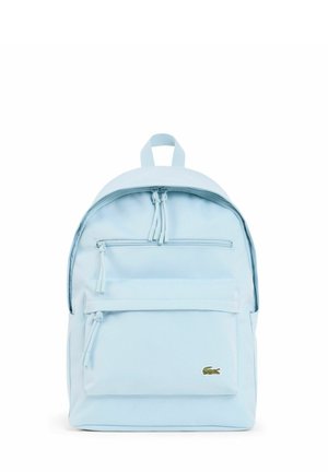 Sac à dos bleu clair avec deux compartiments zippés et un petit logo crocodile vert sur la poche avant.