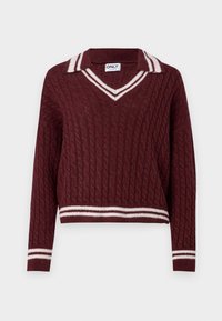 Maglione lavorato a maglia bordeaux con scollo a V e colletto a righe bianche. Presenta motivo a trecce e orlo e polsini a coste. Design di lunghezza croppata.