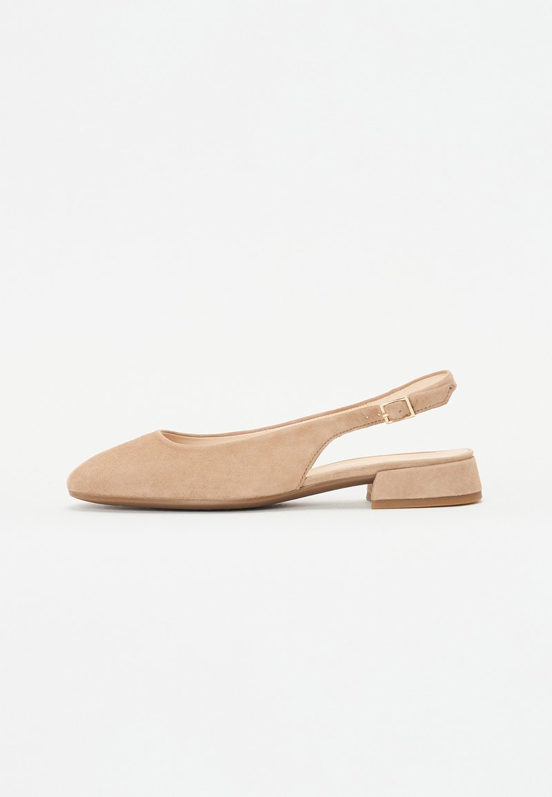 Slingback shoe in soft beige suede with a rounded toe and low block heel. Features an adjustable strap and a minimalistic design.