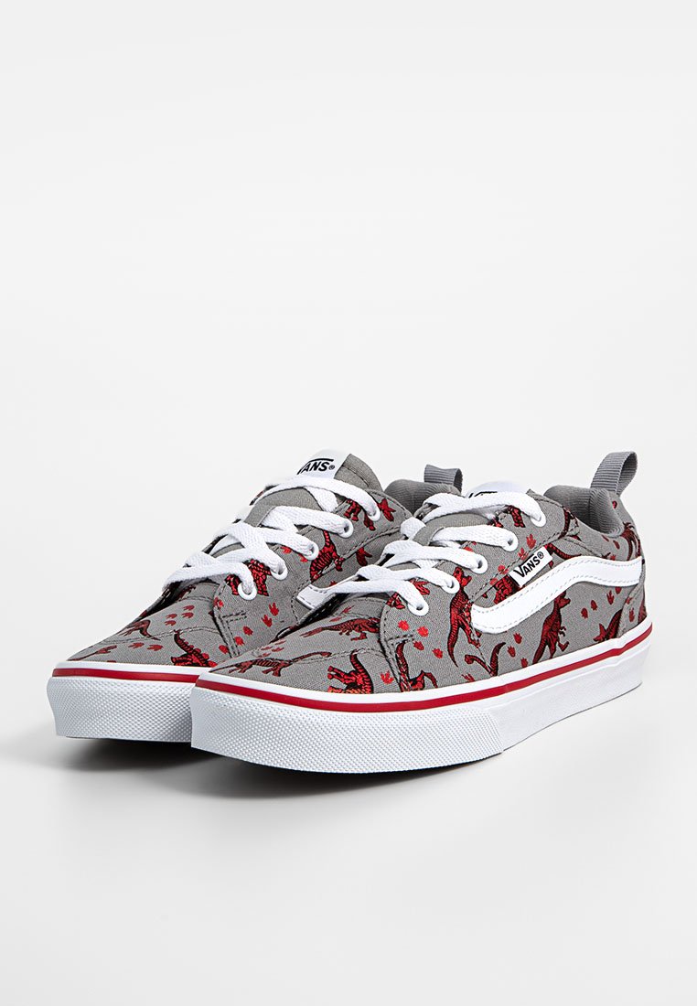 Zapatillas de lienzo grises con estampado de dinosaurios rojos, cordones blancos y suelas de goma blancas, con una franja roja a lo largo de la suela.