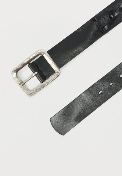 Μαύρη δερμάτινη ζώνη με ορθογώνια ασημένια αγκράφα, που δείχνει τις τρύπες και τη λεπτομέρεια στο άκρο της ζώνης σε λευκό φόντο.