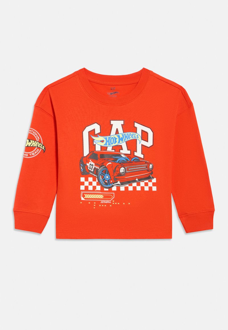 Jasnopomarańczowa koszula z długim rękawem z czerwonym samochodem wyścigowym, literami "GAP" i logo Hot Wheels na przodzie i lewym rękawie.