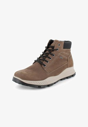 Botas de tobillo de cuero marrón con acentos en negro, diseño con cordones, parte superior texturizada y una suela de goma blanca y negra. Presenta ojales de metal.