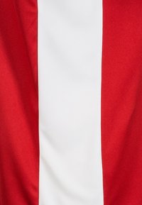 Textil rojo y blanco con una franja roja vertical y gruesa flanqueando una banda central blanca, textura suave, colores vibrantes.