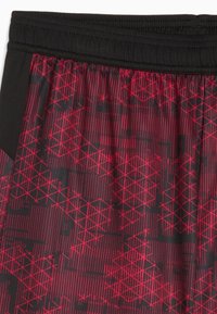 Pantalones cortos deportivos rojos y negros con un patrón geométrico. Cuenta con una cinturilla elástica y una textura suave.