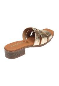 Sandalia tipo slide con un upper texturizado en dorado metálico, que cuenta con tres correas anchas y un tacón de goma marrón. Plantilla suave en beige para mayor comodidad.