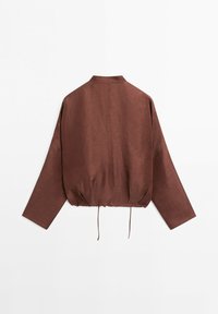 Chemise marron à manches longues avec col montant et ourlet à cordon réglable, présentée à plat sur fond blanc, vue de dos.