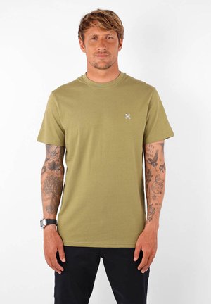 T-shirt en coton vert olive avec un col rond classique et des manches courtes. Présente un petit logo blanc sur la poitrine. Texture lisse.