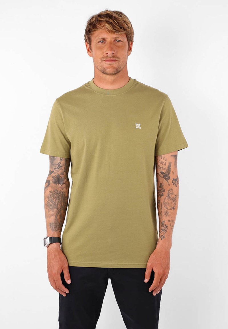 T-shirt en coton vert olive avec un col rond classique et des manches courtes. Présente un petit logo blanc sur la poitrine. Texture lisse.