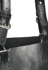 Borsa a tracolla nera in pelle con superficie testurizzata, dotata di hardware in tonalità argento e cinturini regolabili. Logo impresso su un lato.